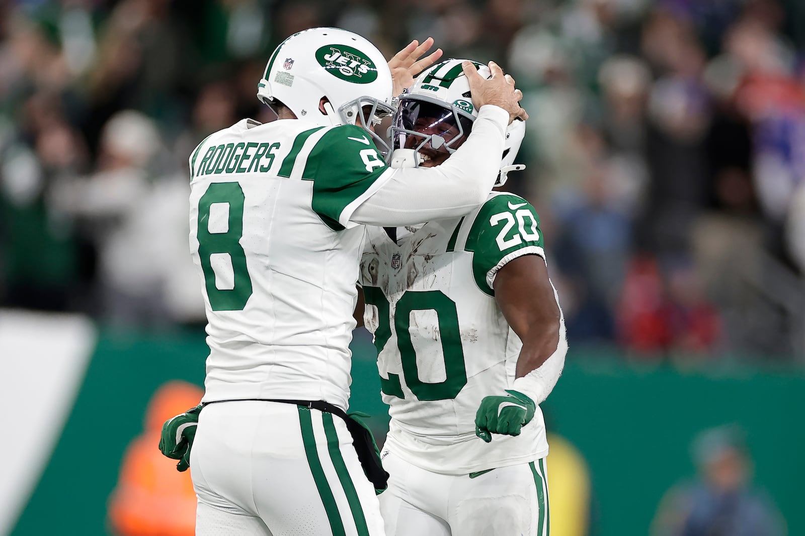 New York Jets quarterback Aaron Rodgers (8) celebrates with running back Frank Gore Jr. (20) after throwing a touchdown pass to wide receiver Allen Lazard during the first half of an NFL football game against the Buffalo Bills in East Rutherford, N.J., Monday, Oct. 14, 2024. (AP Photo/Adam Hunger)