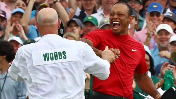 Tiger Woods celebrates with his caddie, Joe LaCava, after winning the Masters Tournament Sunday April 14, 2019, at Augusta National Golf Club in Augusta.