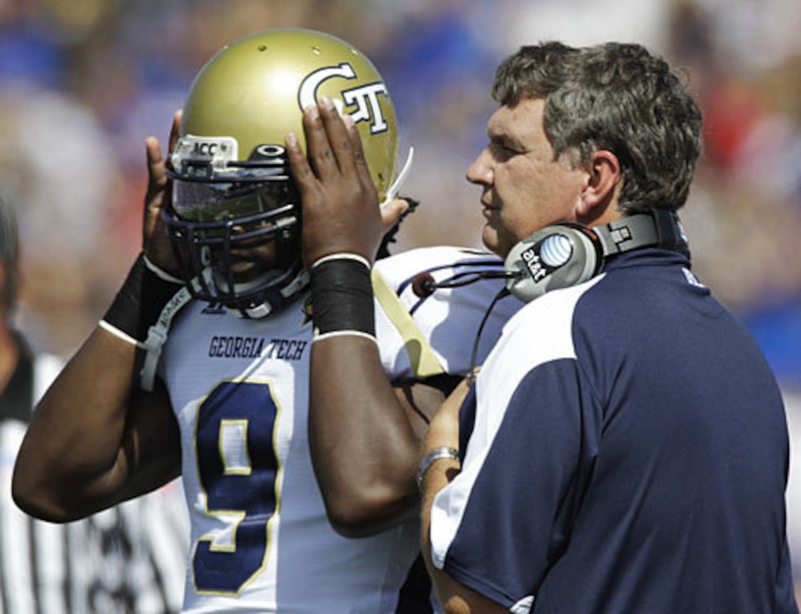 Yellow Jackets quarterback Joshua Nesbitt (9) and coach Paul Johnson talk on the sideline during the first half.