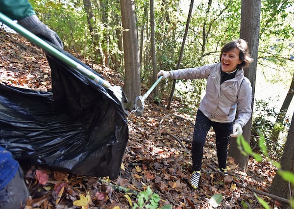 November 16, 2018 Atlanta - Volunteers Doug Rice (left) and Martine Delcroix team up as they walk around to collect trashes alongside the Lake Clara Meer in Piedmont Park on Friday, November 16, 2018. The Piedmont Park Conservancy and volunteers conducted a Lake Clara Meer clean up project by collecting trash from the lake. 