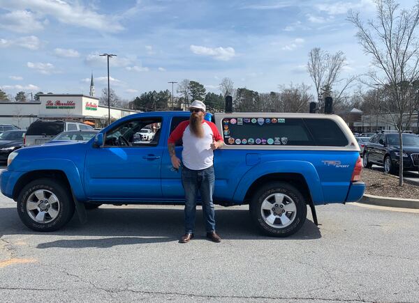 Daniel Keith stands beside the truck that was his home on a cross-country road trip. There is a sticker for each place he camped.
Angela Hansberger for The Atlanta Journal-Constitution