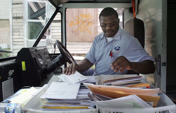 NEW ORLEANS - JULY 18:  United States Postal Service letter carrier Wayne Treaudo delivers mail to a house marked by rescue workers in the Lower Ninth Ward July 18, 2006 in New Orleans, Louisiana. Yesterday was the first day mail service returned to residents of the Lower Ninth since Hurricane Katrina struck nearly eleven months ago.  (Photo by Mario Tama/Getty Images)