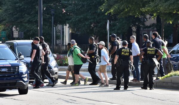 Policemen arrest protesters near Buckhead MARTA transit station during Southeast Climate Strike and Rebellion on Friday, September 27, 2019. Area youth, mainly college students, are set to hold a Southeast Climate Strike and Rebellion at Buckhead MARTA transit station on Friday.