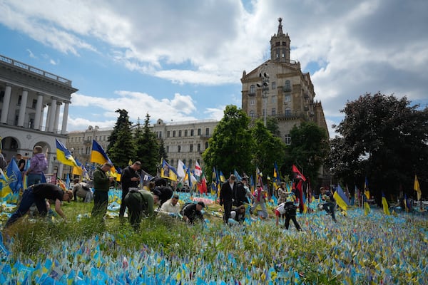 Volunteers put in order the site of an improvised memorial to fallen soldiers on Independence Square in Kyiv, Ukraine, Wednesday, May 15, 2024. (AP Photo/Efrem Lukatsky)