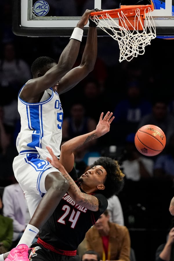 Duke center Khaman Maluach dunks over Louisville guard Chucky Hepburn during the first half of an NCAA college basketball game in the championship of the Atlantic Coast Conference tournament, Saturday, March 15, 2025, in Charlotte, N.C. (AP Photo/Chris Carlson)