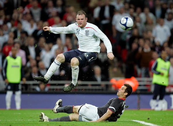 England's Wayne Rooney, top, battles for the ball with Carlos Bocanegra of the U.S. during their international friendly soccer match at Wembley stadium in London, Wednesday May 28, 2008.  England won the match 2-0.  (AP Photo/Alastair Grant)