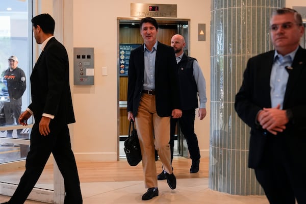 Canada Prime Minister Justin Trudeau briefly speaks to media as he walks through the lobby of the Delta Hotel by Marriott, Saturday Nov. 30, 2024, in West Palm Beach, Fla. (AP Photo/Carolyn Kaster)