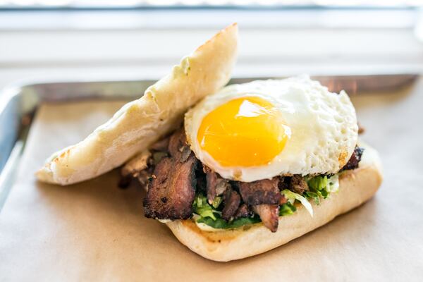 Triple Torta with three kinds of meat, lettuce, avocado aioli, and a fried egg on bread at Porch Light Latin Kitchen. Photo Credit- Mia Yakel. Styling Credit- Chef Andre Gomez