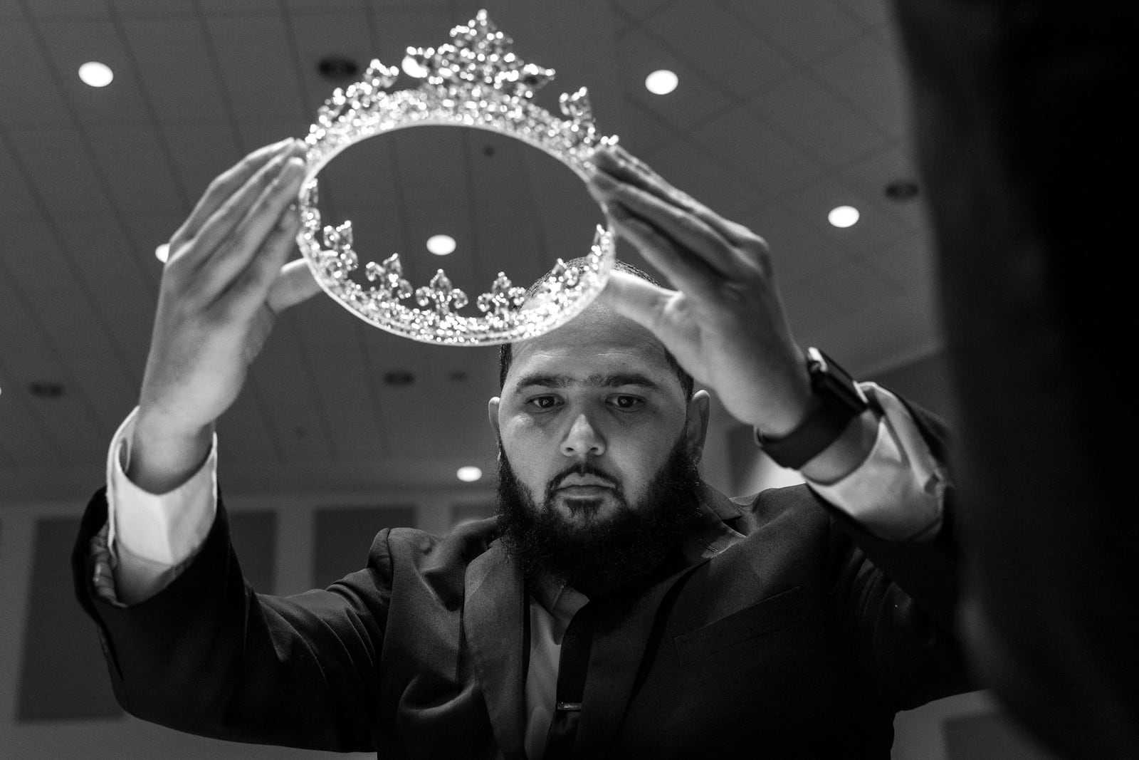 Funeral attendant Preston Hall places a crown on Julian Reeder, as the song “I Shall Wear a Crown” plays.  