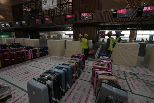 Airport staff members test the luggage machine inside an under construction of a new airport of Techo International Airport at the outskirts of Phnom Penh Cambodia, Friday, March 21, 2025. (AP Photo/Heng Sinith)