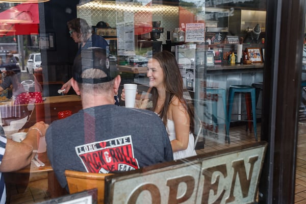 Avery Graus, a senior at Marietta High School enjoys a meal with her parents Mike and Erica at  Red Eyed Mule in Marietta on Thursday, May 23, 2024. Graus will be receiving free meals for life from the restaurant for having perfect attendance since kindergarten. (Natrice Miller/ AJC)