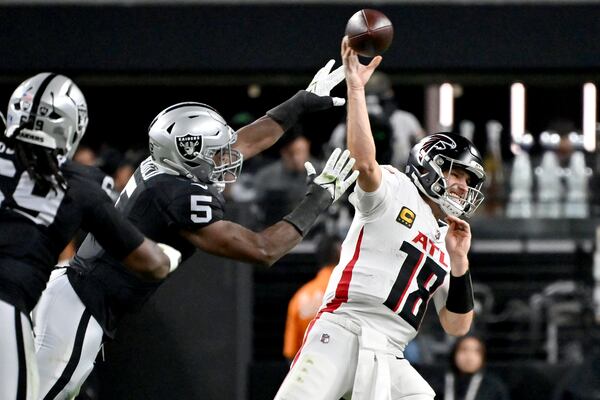 Atlanta Falcons quarterback Kirk Cousins ​​(18) throws under pressure from Las Vegas Raiders linebacker Divine Deablo (5) during the first half of an NFL football game Monday, Dec. 16, 2024, in Las Vegas . (AP Photo/David Becker)