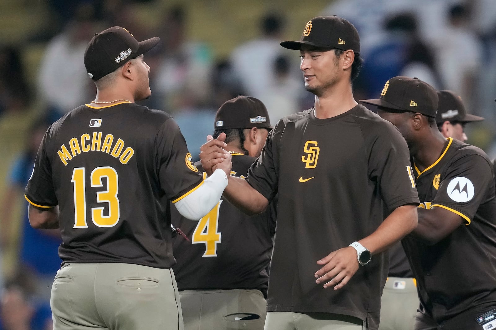 San Diego Padres' Manny Machado, left, shakes hands with pitcher Yu Darvish after a win over the Los Angeles Dodgers in Game 2 of a baseball NL Division Series, Sunday, Oct. 6, 2024, in Los Angeles. (AP Photo/Ashley Landis)