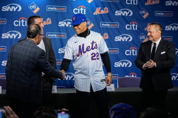 New York Mets owner Steven Cohen, left, shakes hands with Juan Soto, center, as sports agent Scott Boras, right and Mets president of baseball operations David Stearns, look on during a news conference, Thursday, Dec. 12, 2024, in New York. (AP Photo/Frank Franklin II)