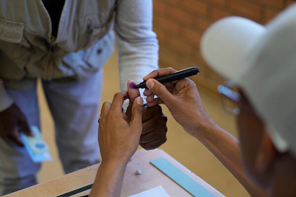 An election official marks a voter's finger with indelible ink at a polling station after casting his vote during the elections at a Mosielele primary school in Moshupa village, Southern District of Botswana, Wednesday, Oct. 30, 2024. (AP Photo/Themba Hadebe)