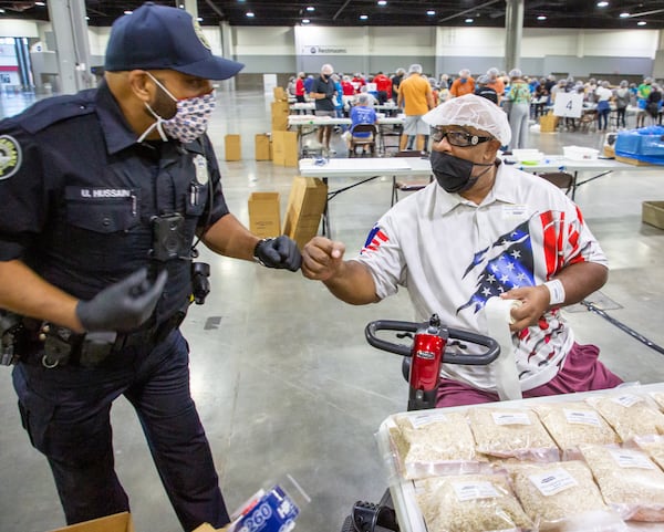 Atlanta Police officer U. Hussain talks with Steve Ludy about their experience in New York City on 911 during the 9/11 National Day of Service at the Georgia World Congress Center Saturday, September 11, 2021. During the event, hundreds of volunteers packed meals for the Atlanta Community Food Bank.  STEVE SCHAEFER FOR THE ATLANTA JOURNAL-CONSTITUTION