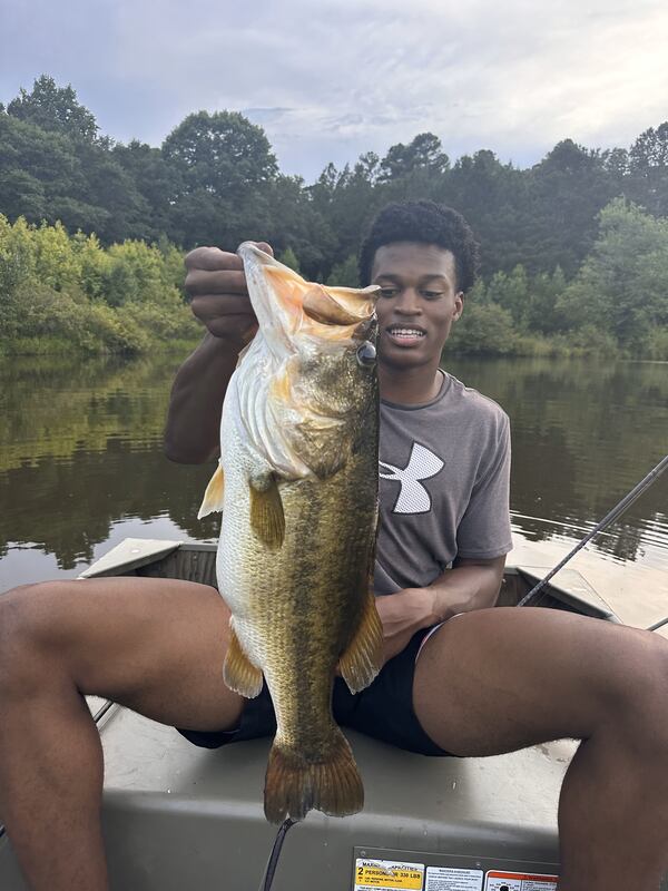 Georgia basketball player RJ Godfrey displays a fish he caught on a lake owned by Georgia basketball coach Mike White in 2024. (Photo courtesy of UGA Athletics)