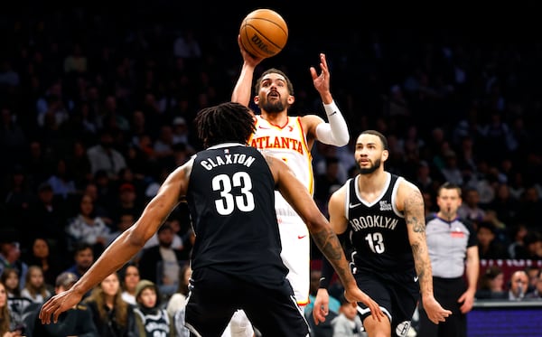 Atlanta Hawks guard Trae Young shoots over Brooklyn Nets center Nic Claxton (33) and guard Tyrese Martin (13) during the second half of an NBA basketball game, Sunday, March 16, 2025, in New York. (AP Photo/Noah K. Murray)