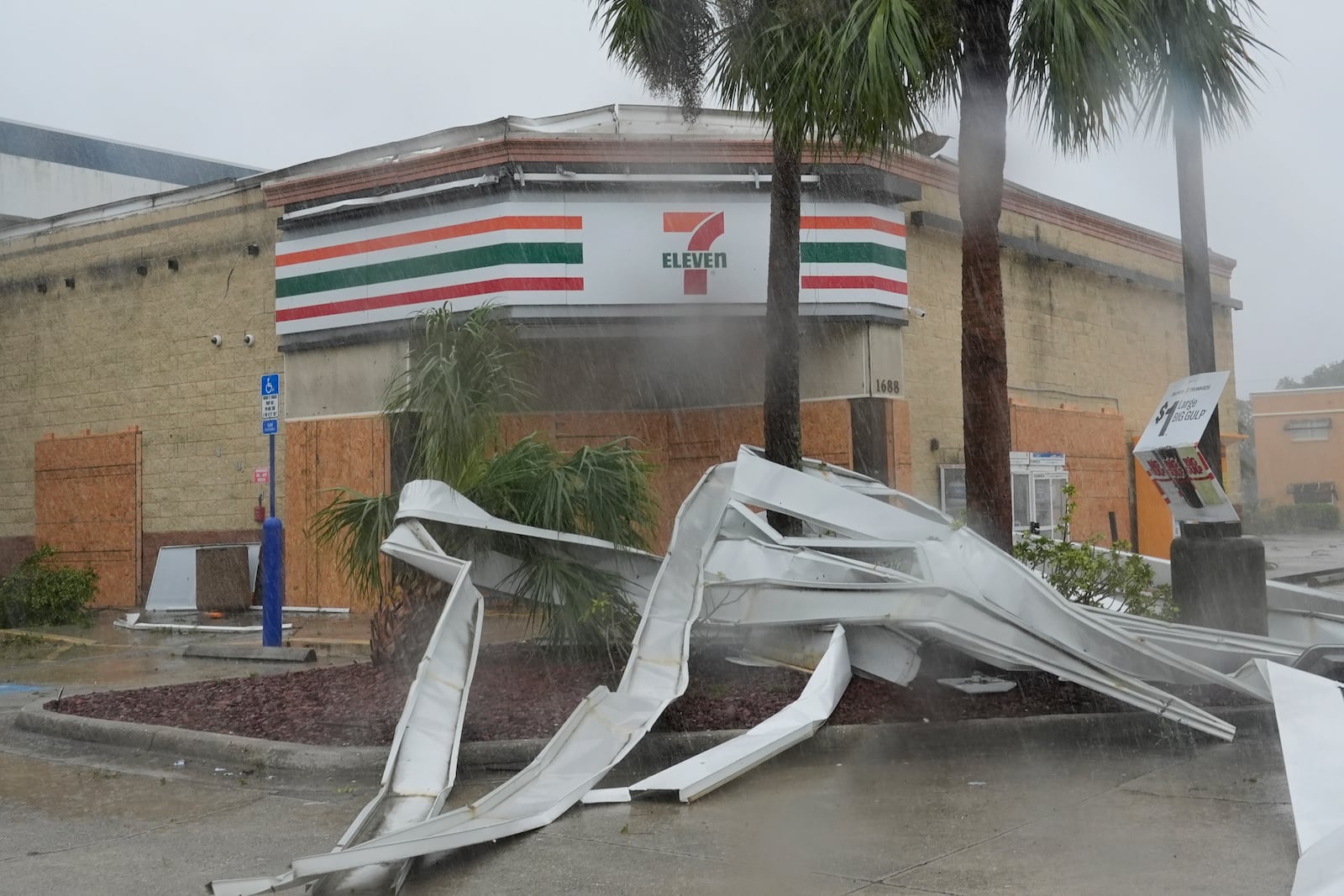 An apparent tornado caused by Hurricane Milton, tore the awning off a 7-Eleven convenient store, Wednesday, Oct. 9, 2024, in Cape Coral, Fla.(AP Photo/Marta Lavandier)