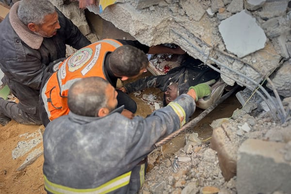 EDS NOTE GRAPHIC CONTENT.- Rescue workers and volunteers attempt to pull the body of a man from the rubble following an Israeli army airstrike in Khan Younis, southern Gaza Strip, Thursday, March 20, 2025. (AP Photo/Mariam Dagga)