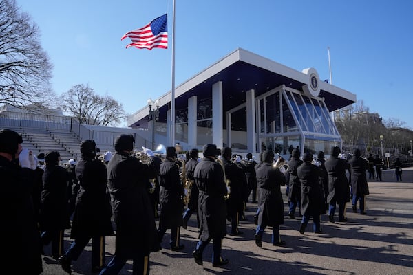 With the American flag flying at half staff in honor of former President Jimmy Carter, members of the U.S. Marine Band march on Pennsylvania Avenue during a parade rehearsal for the upcoming inauguration of Donald Trump in Washington.