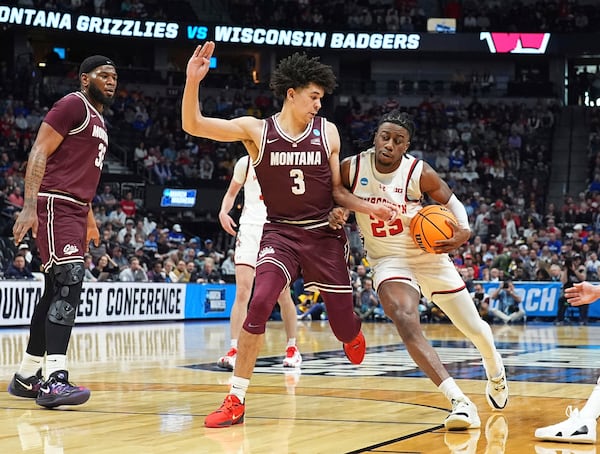 Wisconsin guard John Blackwell, right, drives the lane as Montana guard Malik Moore defends during the first half in the first round of the NCAA college basketball tournament Thursday, March 20, 2025, in Denver. (AP Photo/David Zalubowski)