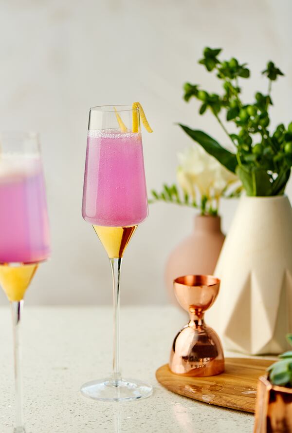 Fresh lemon juice added to the gin changes the violet-hued Empress 75 drink to pink. Courtesy of Empress