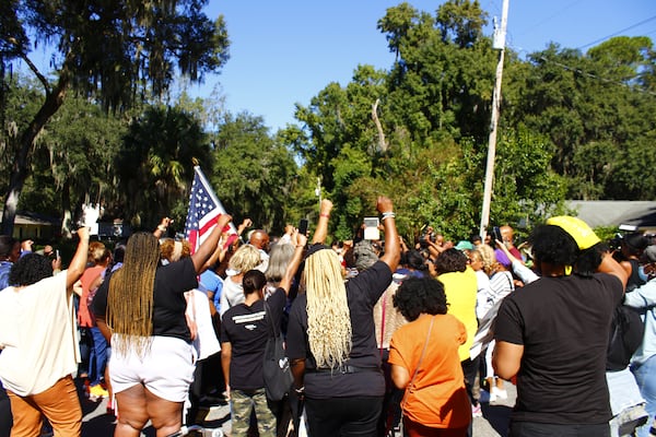 Supporters of the Arbery family and members of the Transformative Justice Coalition gather in the street around the place where Ahmaud Arbery was fatally shot last year. 