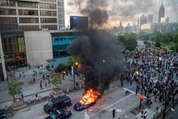 05/29/2020 - Atlanta, Georgia - An Atlanta Police Department patrol car is engulfed in flames after demonstrators set it ablaze and destroyed other patrol cars outside of the CNN Center in Atlanta, Friday, May 29, 2020. Following a peaceful march to the Georgia State Capitol to protest racial injustice and police brutality, demonstrators returned to the area around Centennial Olympic Park and CNN center and clashed with police. (ALYSSA POINTER / ALYSSA.POINTER@AJC.COM)