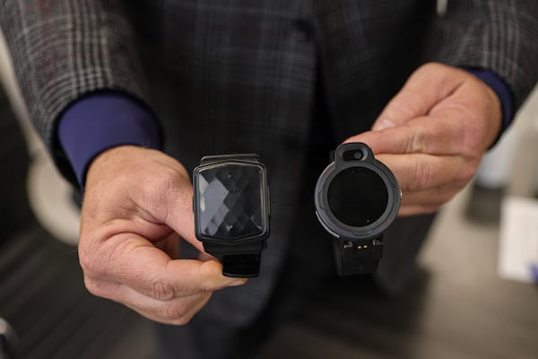 Micah Garvey, Vice President of Business Development at Talitrix shows the inmate wristband (left) and the wristbands for those out of jail (right) on Friday, November 17, 2023. The wristband, which is a replacement for ankle montiors, provides biometric monitoring as well as live-time tracking for inmates as well as those on probation. (Natrice Miller/ Natrice.miller@ajc.com)