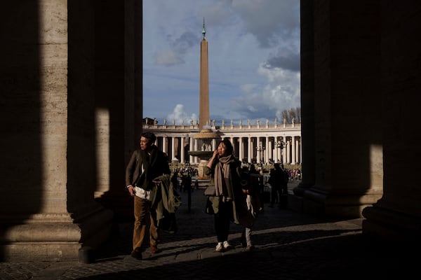 Tourists walk through St. Peter's Square in the Vatican, Friday, Feb. 28, 2025. (AP Photo/Bernat Armangue)