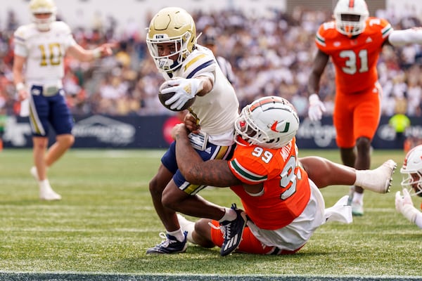 Georgia Tech wide receiver Malik Rutherford, left, reaches over the goal line while being tackled by Miami defensive lineman Ahmad Moten Sr. (99) during the first half of an NCAA college football game, Saturday, Nov. 9, 2024, in Atlanta. (AP Photo/Jason Allen)