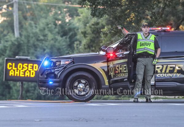 A Cherokee County sheriff's deputy directs traffic away from the scene Thursday morning.