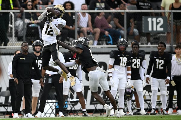 FILE - Colorado wide receiver Travis Hunter (12) catches a pass over Central Florida defensive back Brandon Adams (0) defends during the first half of an NCAA college football game, Saturday, Sept. 28, 2024, in Orlando, Fla. (AP Photo/Phelan M. Ebenhack, File)