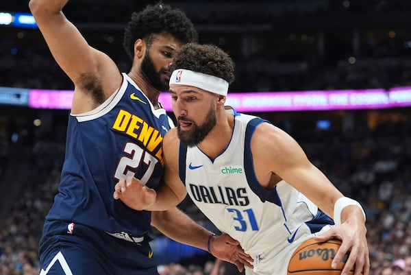 Dallas Mavericks guard Klay Thompson, front, drives past Denver Nuggets guard Jamal Murray in the first half of an NBA basketball game, Sunday, Nov. 10, 2024, in Denver. (AP Photo/David Zalubowski)