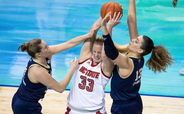 North Carolina State's Elissa Cunane (33) battles in the post against Georgia Tech's Lotta-Maj Lahtinen, left, and Lorela Cubaj, right, during an NCAA college basketball game in the semifinals of Atlantic Coast Conference tournament in Greensboro, N.C., Saturday, March 6, 2021. (AP Photo/Ben McKeown)