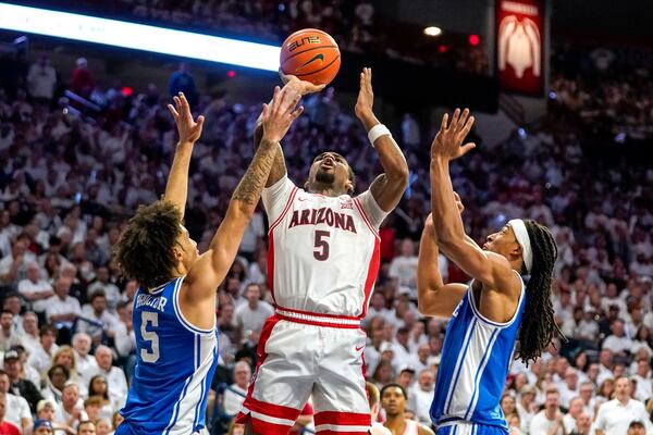 Arizona Wildcats guard KJ Lewis (5) shoots between Duke guard Tyrese Proctor (5) and forward Maliq Brown (6) during the second half of an NCAA college basketball game Friday, Nov. 22, 2024, in Tucson, Ariz. (AP Photo/Darryl Webb)