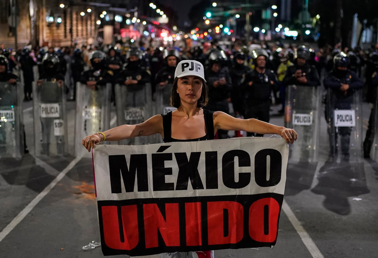 Student Daniela Camberos shows a banner in front of the police during a protest against government's proposed judicial reform, which would make judges stand for election, outside the Senate in Mexico City, Tuesday, Sept. 10, 2024. (AP Photo/Felix Marquez)