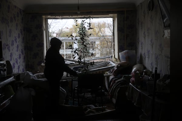 A woman clear the rubble inside her apartment at a hostel for displaced persons damaged by a Russian strike in Zaporizhzhia, Ukraine, Nov. 11, 2024. (AP Photo/Kateryna Klochko)