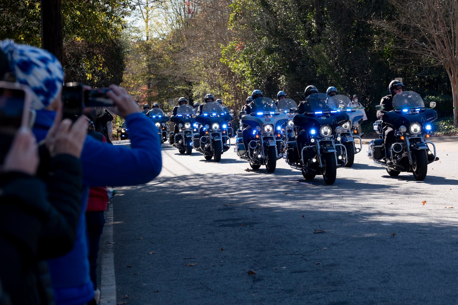 People on the edge of the Emory campus watch as a motorcade brings former First Lady Rosalynn Carter’s remains to a memorial service in Atlanta on Tuesday, Nov. 28, 2023.   (Ben Gray / Ben@BenGray.com)