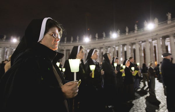 FILE - Nuns hold candles during a rosary vigil prayer in St. Peter's Square at The Vatican for Pope John Paul II's health Friday, April 1, 2005 (AP Photo / Luca Bruno, File )