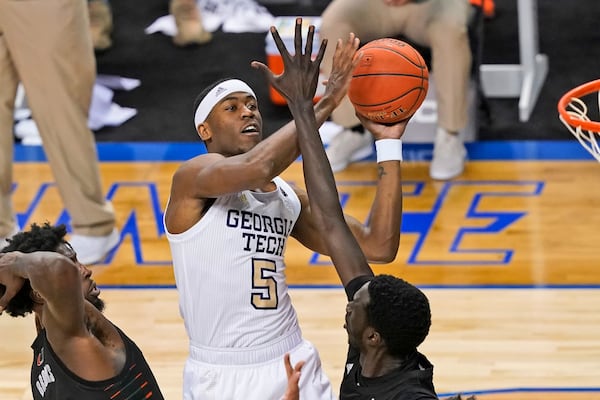 Georgia Tech forward Moses Wright (5) goes up for a shot as Miami center Nysier Brooks (3) and Miami forward Deng Gak, right, defend during the first half of an NCAA college basketball game in the quarterfinal round of the Atlantic Coast Conference tournament in Greensboro, N.C., Thursday, March 11, 2021. (AP Photo/Gerry Broome)