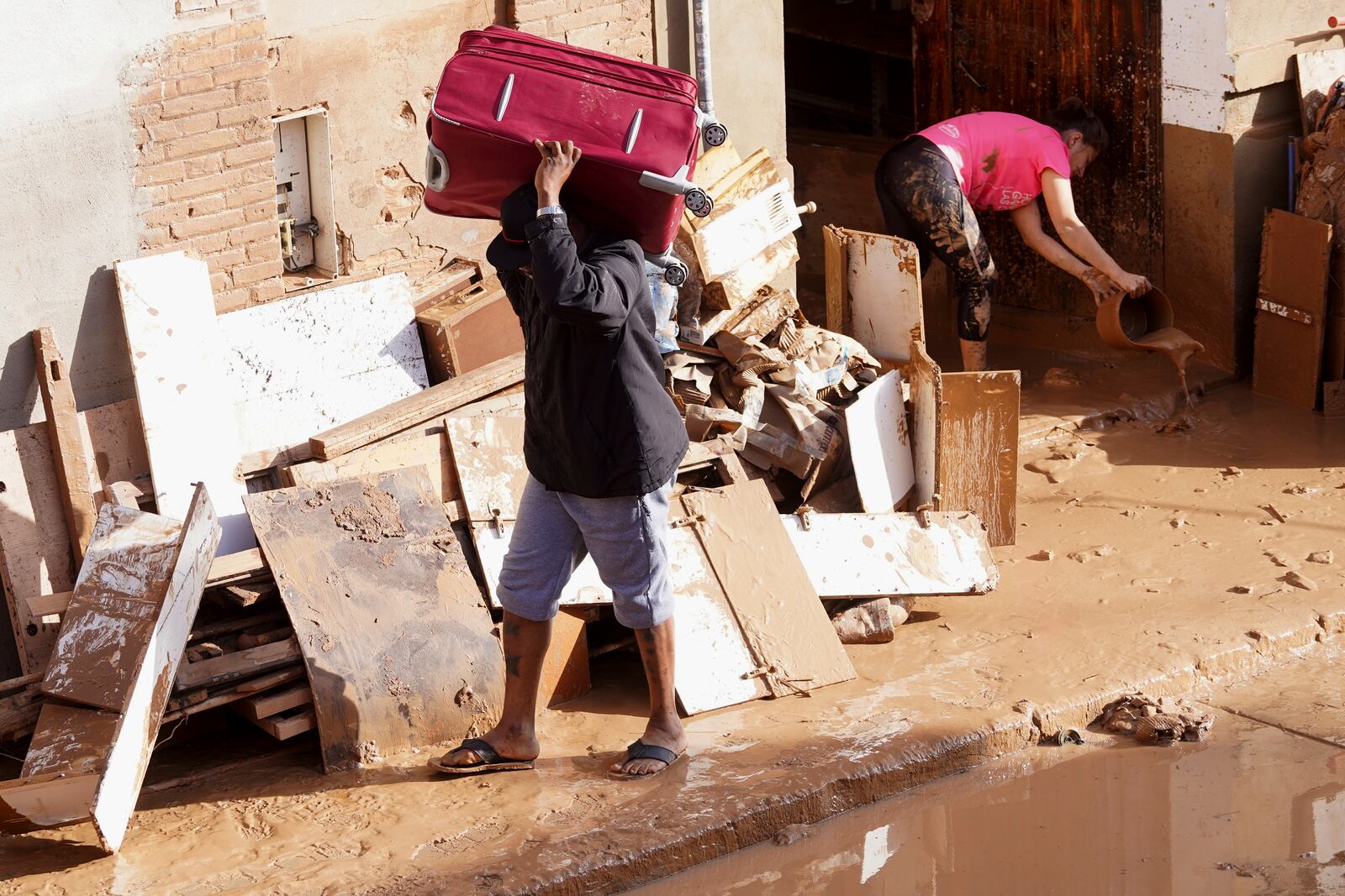 Residents clean their house affected by floods in Valencia, Spain, Thursday, Oct. 31, 2024. (AP Photo/Alberto Saiz)