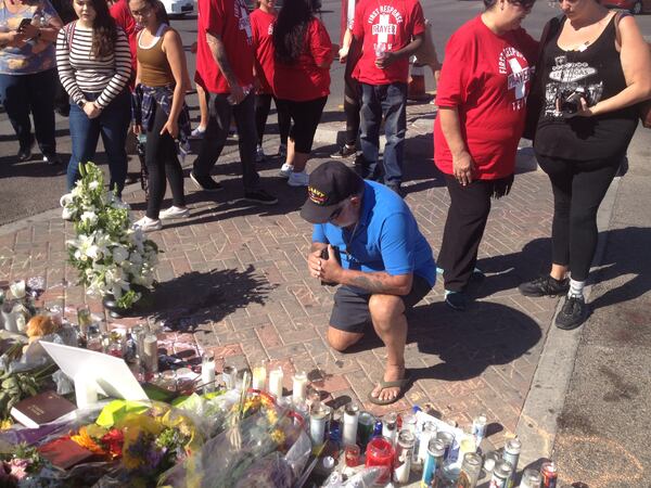 Rick Alexander prays at a makeshift memorial built for the victims of the shooting. (Ernie Suggs / AJC)