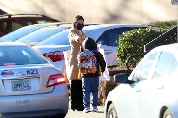 School administrators at Norcross Elementary School welcome students on Jan. 10, 2022. Across Georgia, schools are determined to keep their doors open amid high coronavirus rates that have led to staffing shortages. (Miguel Martinez for The Atlanta Journal-Constitution)