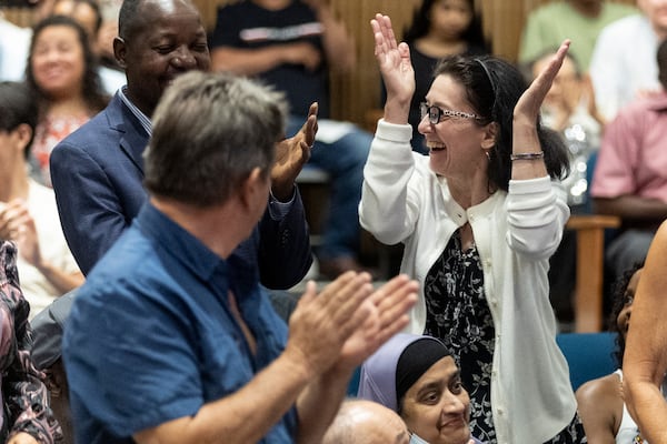 Some of the 150 participants stand and celebrate when their country is being called during the naturalization ceremony at the Gwinnett Justice Administration Center Tuesday July 2 2024. (Steve Schaefer / AJC)