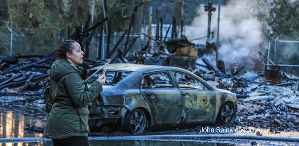 Elizabeth Somerville shows her mother via FaceTime the damage to her apartment. JOHN SPINK / JSPINK@AJC.COM