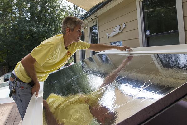 George Faughnan shows the reflective side of The Hate Shield, a mobile, reflective and soundproof wall, created by visual artist Matthew Terrell, at a residence in Atlanta. (Alyssa Pointer/alyssa.pointer@ajc.com)