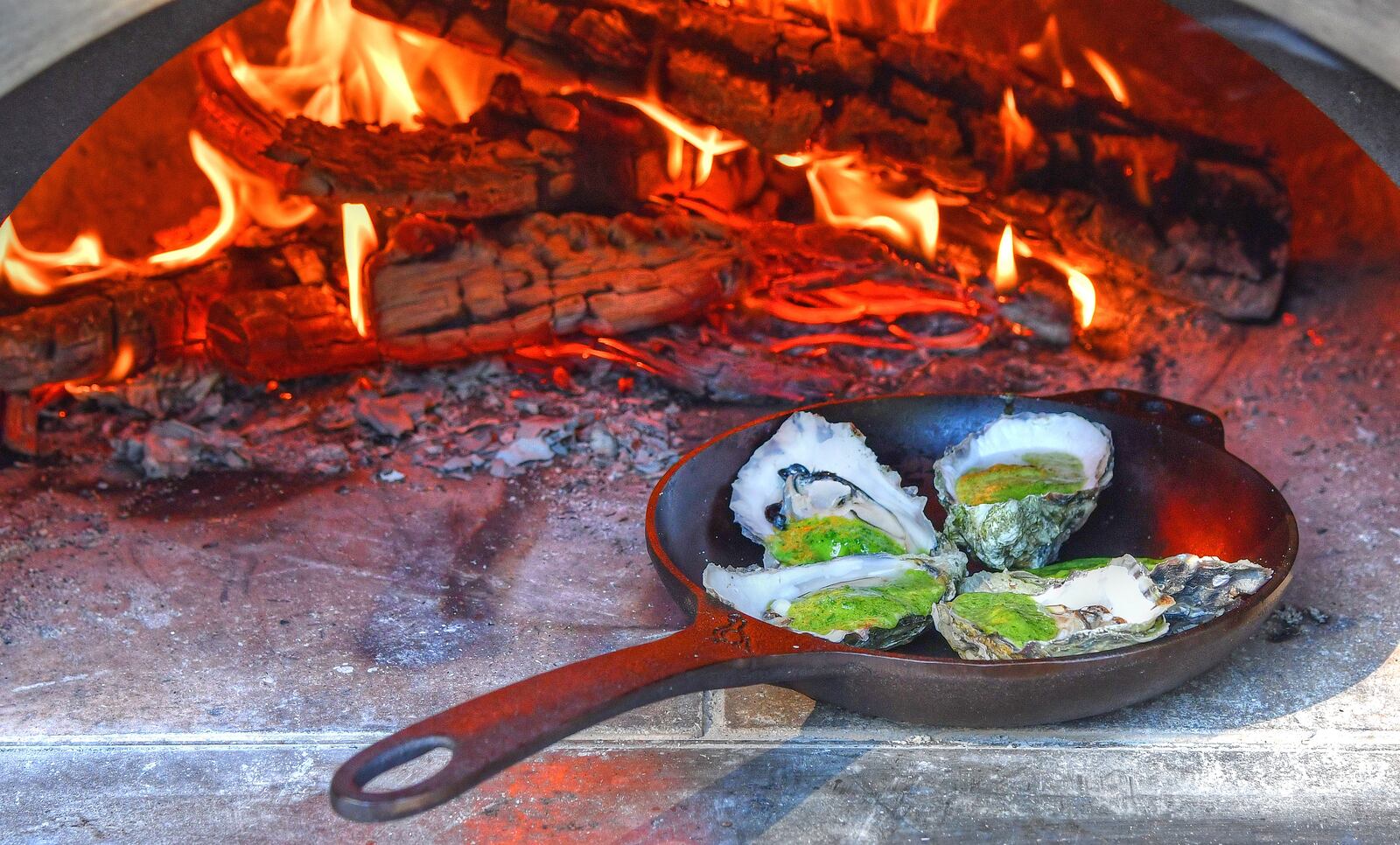 Oysters with herb butter roast in a wood-fired oven, but that's not your only option. (Food styling by Brian Wolfe and Bryan Rackley / Chris Hunt for The AJC)