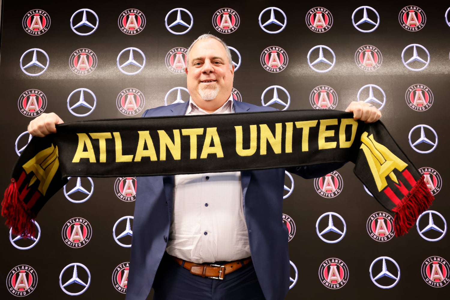 Atlanta United CEO/President Garth Lagerwey poses with the Atlanta United scarf after being introduced during his  news conference Tuesday at Mercedes-Benz Stadium. (Miguel Martinez / miguel.martinezjimenez@ajc.com)